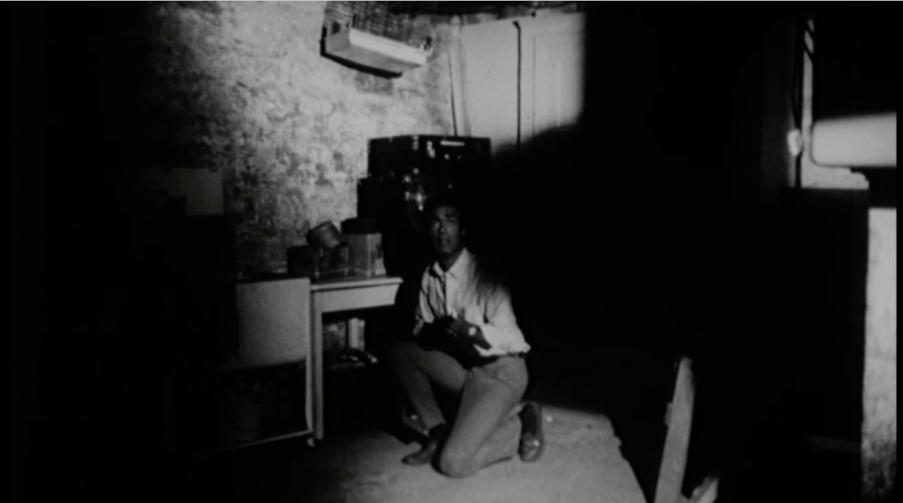 man kneels in a room