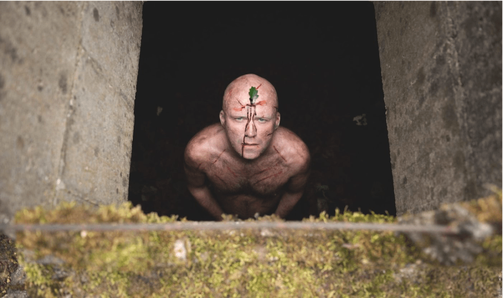 man looks up from hole in the ground
