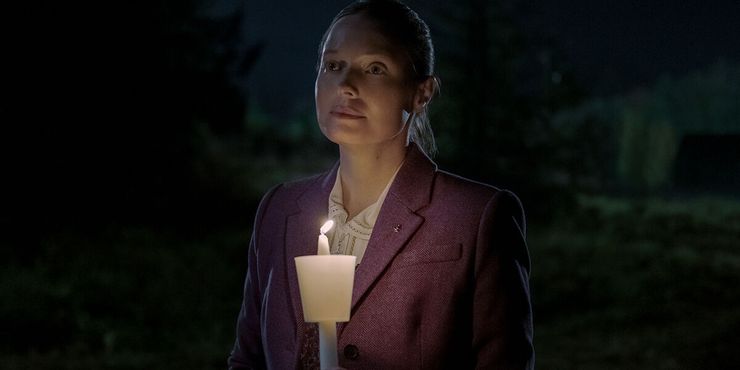 A woman illuminated by a burning candle