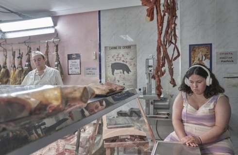 a girl wearing headphones sits in a meat market