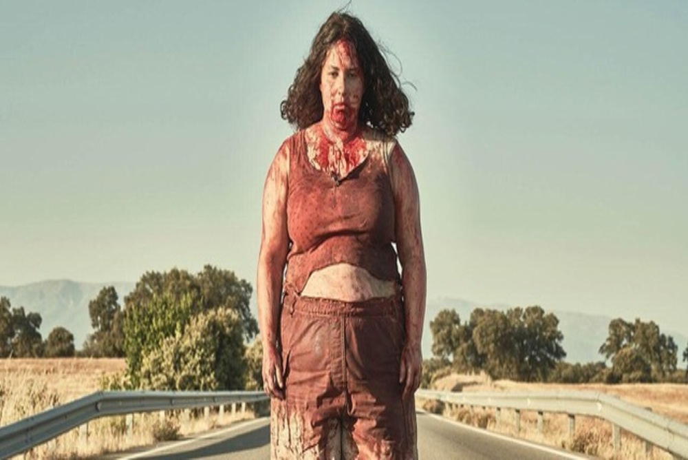 a bloodied girl stands on an open road