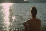 man on beach watches man on water