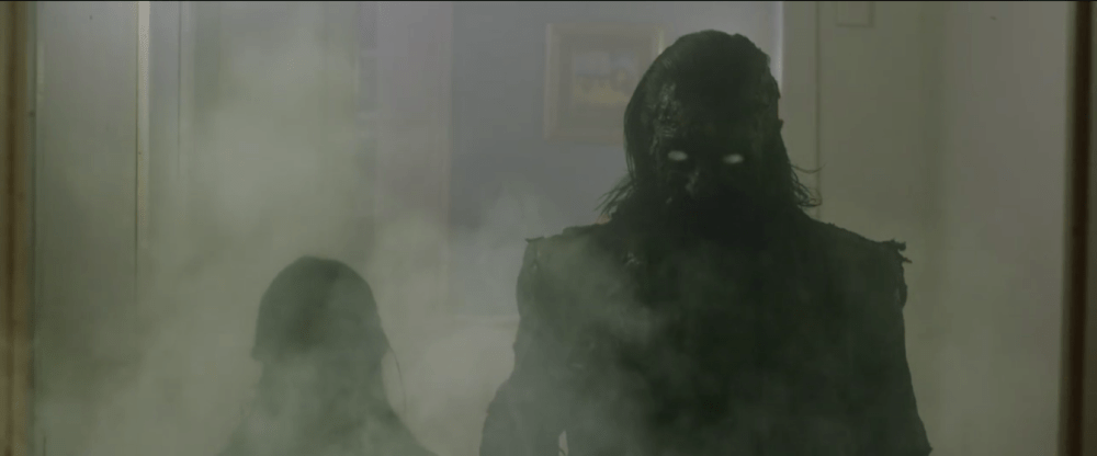 smoke obscures two figures, one of which appears to be a burned person