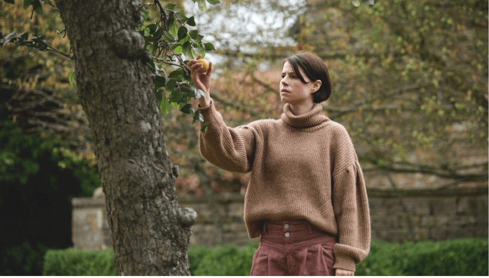 a woman reaches for an apple