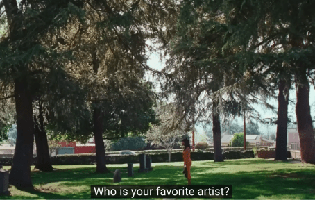 a girl stands in a tree lined graveyard on a sunny day